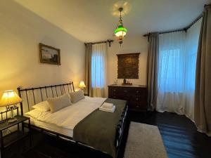 a bedroom with a bed and a chandelier at Casa Alexandra Slătineanu in Bran +20 photos