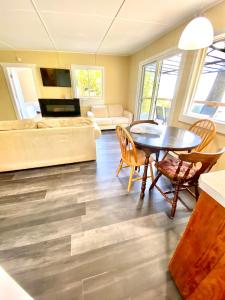 a living room with a table and chairs and a couch at Cedar House Ocean View & Access in Roberts Creek