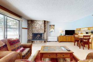 a living room with a couch and a table and a fireplace at Lichenhearth # 4 in Snowmass Village