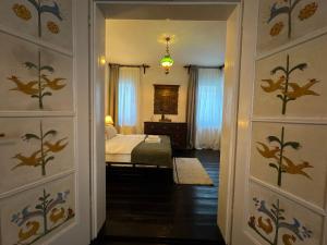 a bedroom with a bed and a bedroom door withpainted walls at Casa Alexandra Slătineanu in Bran
