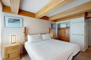 a bedroom with a large white bed and a kitchen at Vail International #3 in Vail +24 photos