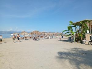 a group of people on a beach with chairs and umbrellas at on the STRIP studio 3 in Kavos