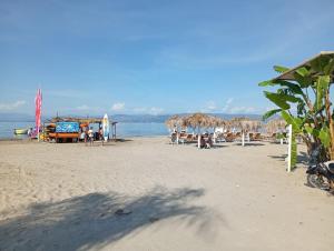 a beach with umbrellas and chairs and the ocean at on the STRIP studio 3 in Kavos