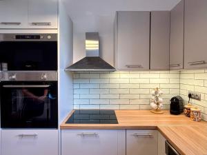 a kitchen with white cabinets and a stove top oven at Mosaic House in Sami
