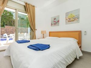 a bedroom with a white bed with two blue towels on it at Villa Palmbeach by Interhome in Lloret de Mar