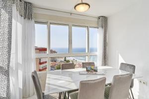 a dining room with a table and chairs and a large window at Mirador del Mar in Torrox Costa
