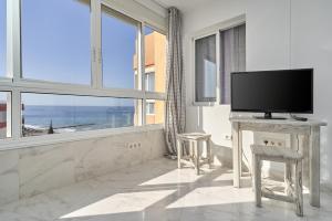 a living room with a tv and a large window at Mirador del Mar in Torrox Costa