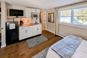 a kitchen with white cabinets and a black refrigerator at Okemo Era in Ludlow