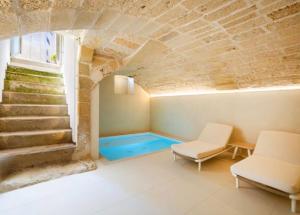 a room with a swimming pool in a stone building at Casa Novecentoundici in Castrignano deʼ Greci