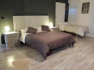ein Schlafzimmer mit einem großen Bett und zwei Nachttischen in der Unterkunft La Casa del Colonnello in Vercelli