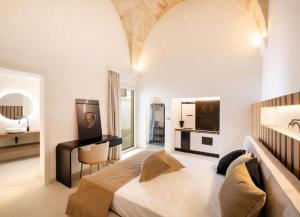 a bedroom with a large bed and a desk at Casa Novecentoundici in Castrignano deʼ Greci +15 photos