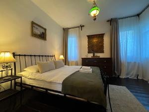 a bedroom with a bed and a lamp and curtains at Casa Alexandra Slătineanu in Bran