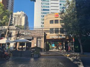 a building with a burger king sign on a street at Manuel Montt Spot by AndesPlus in Santiago