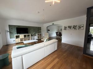 a living room with a white couch and a tv at Niederrhein Suite Kerken in Kerken