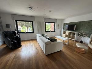 a living room with a white couch and a table at Niederrhein Suite Kerken in Kerken