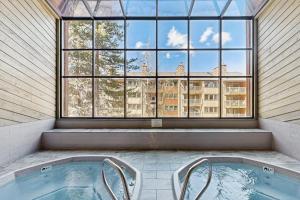 a hot tub in a room with a large window at Cimarron #305 in Breckenridge