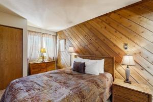 a bedroom with a large bed with wooden walls at Cimarron #305 in Breckenridge +56 photos