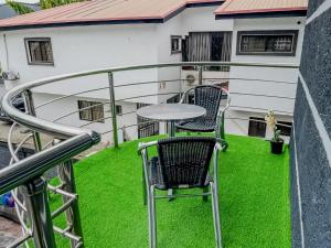 a balcony with two chairs and a table at Blooms Manor Apartment in Lagos