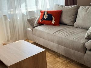a couch with a red pillow and a coffee table at Ferienwohnung Eulenwinkel in Pappenheim