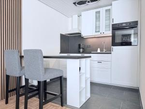 a kitchen with white cabinets and a table and chairs at Ferienwohnung Eulenwinkel in Pappenheim