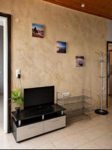 a living room with a flat screen tv on a wall at Sunray Separate Villa in Skala Sotiros