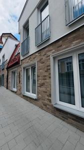 a brick building with windows and balconies on it at Apartamenty Nadjeziorna in Ełk
