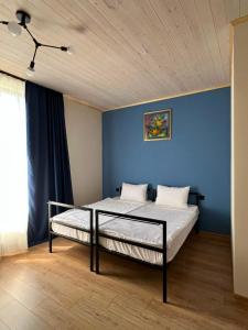 a bedroom with two beds and a blue wall at Malina Utsera in Oni