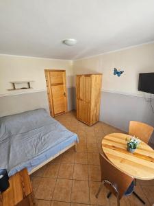 a bedroom with a bed and a wooden table at Margaretka in Łeba