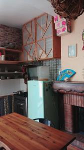 a kitchen with a wooden table and a refrigerator at Cool in Cévennes in Le Vigan