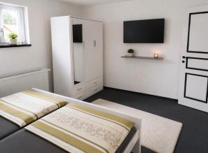 a white room with a bed and a tv at Villa Dani in Bihać