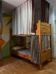 a bedroom with a bunk bed with a curtain at Just a Hostel in Sozopol