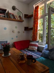 a living room with a red couch and a table at Just a Hostel in Sozopol