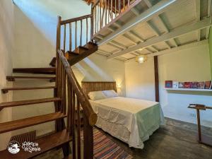 a bedroom with a bed next to a staircase at Chalés Canoa in Ilhabela