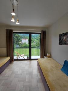 a bedroom with a bed and a large window at Apartament Parkowa 8 in Myślenice
