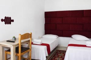 a room with two beds and a table and a chair at Hotel Erisun in Vlorë +7 photos
