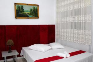a room with two beds and a picture on the wall at Hotel Erisun in Vlorë