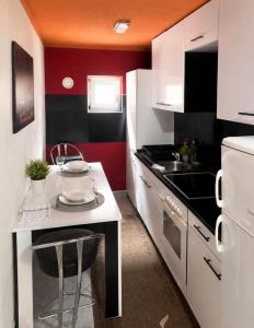 a small kitchen with a white and red wall at Villa Dani in Bihać