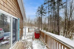 a balcony with snow on the ground next to a house at Fornuto Cabin in Wardsboro