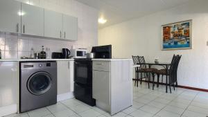 a kitchen with a washing machine and a table with chairs at Light Hall in Johannesburg