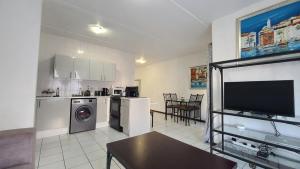 a kitchen with a living room with a tv at Light Hall in Johannesburg