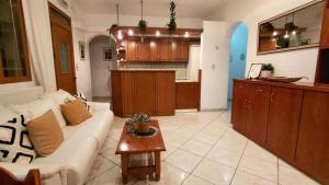 a living room with a white couch and a kitchen at Argyroupolis Dimitris Rooms in Argyroupolis