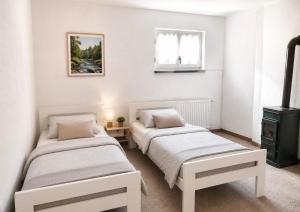two beds in a room with white walls at Villa Dani in Bihać