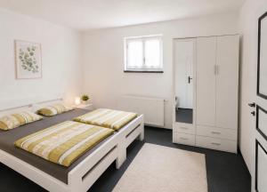 a white bedroom with a bed and a white cabinet at Villa Dani in Bihać