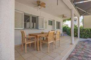 a dining room table and chairs on a patio at Apartments at Frapa in Rogoznica