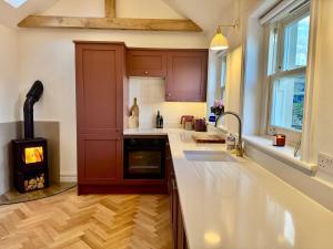 a kitchen with a wood stove in the middle of it at Luxury cottage for 2 in Castleton - Peak District retreat - Panoramic Views & Log burner in Castleton