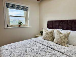 a bedroom with a large bed with a window at Luxury cottage for 2 in Castleton - Peak District retreat - Panoramic Views & Log burner in Castleton