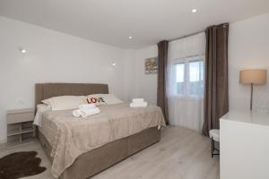 a bedroom with a bed with a love pillow on it at Villa The Rock in Unešić +27 photos