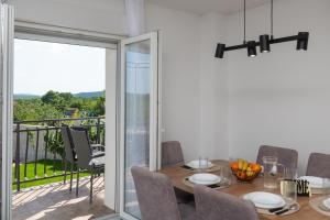 a dining room with a table and a balcony at Villa The Rock in Unešić