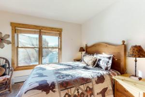 a bedroom with a bed and a window at Tenderfoot Lodge 2621 in Keystone