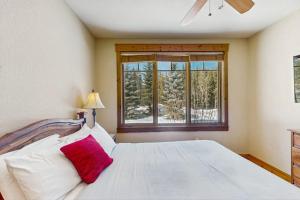 a bedroom with a white bed and a window at Settler's Creek 6524 in Keystone